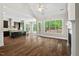 Open living room with views into the modern kitchen and a wall of bright windows to the outdoor scenery at 344 Colonial Ridge Dr, Pittsboro, NC 27312