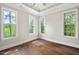 Bright empty room featuring hardwood floors and natural light from the multiple large windows at 344 Colonial Ridge Dr, Pittsboro, NC 27312