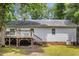 Exterior view of home with a wooden deck and stairs leading to a well-maintained backyard at 352 Riverstone Dr, Clayton, NC 27527