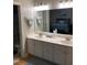 Bathroom featuring a double sink vanity, large mirror, and adjacent bedroom at 352 Riverstone Dr, Clayton, NC 27527