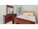 Cozy bedroom with a cherry wood dresser and bed frame with soft, inviting textiles at 352 Riverstone Dr, Clayton, NC 27527