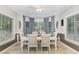 Formal dining room featuring wainscoting, ceiling fan, and bay window with stylish curtains at 352 Riverstone Dr, Clayton, NC 27527
