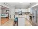 Well-lit kitchen with white cabinets, granite countertops, stainless steel appliances, and an island with breakfast bar seating at 352 Riverstone Dr, Clayton, NC 27527