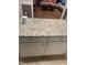 Close-up of kitchen island with granite countertops, white cabinetry, and a view of the living room at 352 Riverstone Dr, Clayton, NC 27527