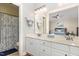 Well-lit main bathroom featuring double sinks, white cabinets, and separate toilet area at 352 Riverstone Dr, Clayton, NC 27527