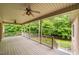A covered outdoor porch offers serene views, ceiling fans, and a great space for relaxing outdoors at 3994 Limerick Dr, Burlington, NC 27215
