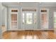 Light-filled foyer with hardwood floors and a decorative glass front door, sidelights, and transom at 3994 Limerick Dr, Burlington, NC 27215