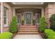 Charming brick home entrance with meticulously landscaped front steps, columns, and decorative door at 3994 Limerick Dr, Burlington, NC 27215