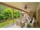 Inviting covered patio features ceiling fans, brick accents, and wood railing overlooking the manicured lawn at 3994 Limerick Dr, Burlington, NC 27215