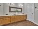 Bathroom featuring a double vanity, wooden cabinets, decorative mirror, and wood-look flooring at 418 Old Scarborough Ln, Garner, NC 27529