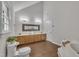 Bathroom boasts a vaulted ceiling, double vanity, wood-look floors, and separate tub and toilet at 418 Old Scarborough Ln, Garner, NC 27529