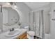 Bathroom featuring a single vanity, a round mirror, and a shower/tub combination with curtain at 418 Old Scarborough Ln, Garner, NC 27529