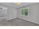 Bedroom with neutral carpet, large windows overlooking greenery, and a ceiling fan at 418 Old Scarborough Ln, Garner, NC 27529