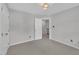 Bedroom with neutral carpet, light fixture, and open door to the carpeted upstairs hallway at 418 Old Scarborough Ln, Garner, NC 27529