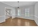Bright, empty dining room with hardwood floors, shuttered windows, and a view of the staircase at 418 Old Scarborough Ln, Garner, NC 27529