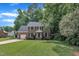 Traditional two-story brick home with an attached garage and a well-maintained lawn surrounded by mature trees at 418 Old Scarborough Ln, Garner, NC 27529