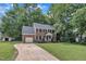 Classic two-story brick home with an attached garage, long driveway, and a well-manicured lawn with mature trees at 418 Old Scarborough Ln, Garner, NC 27529