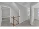 Upstairs hallway with carpet and wooden railing leads to multiple rooms and a window at 418 Old Scarborough Ln, Garner, NC 27529