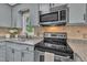Updated kitchen features stainless appliances, tile backsplash, and granite countertops at 418 Old Scarborough Ln, Garner, NC 27529
