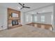 Open living room featuring a fireplace, two ceiling fans, hardwood floors, and neutral carpet and paint at 418 Old Scarborough Ln, Garner, NC 27529