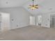 Carpeted main bedroom with a vaulted ceiling, ceiling fan and two doorways, one leading to an ensuite bathroom at 418 Old Scarborough Ln, Garner, NC 27529