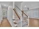 Open staircase with carpeted steps and wooden handrail, leading to an open space with hardwood flooring at 418 Old Scarborough Ln, Garner, NC 27529