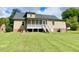 Back exterior view featuring a screened-in porch, stairs, and well-maintained lawn at 4200 Harmony Church Rd, Efland, NC 27243