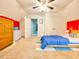 Spacious bedroom with ceiling fan, closet, and bright red accent wall at 4200 Harmony Church Rd, Efland, NC 27243