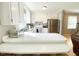 Bright kitchen featuring white cabinetry, stainless steel refrigerator, and laminate flooring at 4200 Harmony Church Rd, Efland, NC 27243