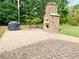 Outdoor patio featuring a brick pizza oven, stone pavers, and a grill at 4200 Harmony Church Rd, Efland, NC 27243