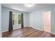 Bedroom boasts blue walls, hardwood floors, closet, and a backyard view at 4401 Liverpool Ln, Raleigh, NC 27604