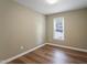 Bedroom features hardwood floors, green walls, and a window overlooking the neighborhood at 4401 Liverpool Ln, Raleigh, NC 27604