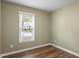 Bedroom features hardwood floors, green walls, and a window overlooking the neighborhood at 4401 Liverpool Ln, Raleigh, NC 27604