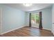 Bedroom features hardwood floors, blue walls, a window, and a closet at 4401 Liverpool Ln, Raleigh, NC 27604