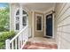 Inviting front porch with brick steps, white railings, and an arched window to bring in natural light at 4401 Liverpool Ln, Raleigh, NC 27604