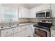 Galley kitchen featuring granite countertops, white cabinetry and stainless steel appliances at 4401 Liverpool Ln, Raleigh, NC 27604
