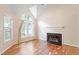 Living room showcasing hardwood floors, fireplace, and large window with backyard view at 4401 Liverpool Ln, Raleigh, NC 27604