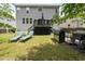 Expansive backyard featuring a deck, lounge chairs, a grill, and landscaped flower beds at 507 Littleport Dr, Rolesville, NC 27571