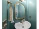 Stylish half-bathroom featuring modern fixtures, a decorative mirror, and teal walls at 507 Littleport Dr, Rolesville, NC 27571