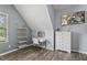 Cozy bedroom features a desk, shelving, a TV, and a dresser with warm, wood-look floors at 507 Littleport Dr, Rolesville, NC 27571