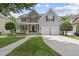 Charming two-story home features a stone facade, inviting front porch, and a well-manicured lawn at 507 Littleport Dr, Rolesville, NC 27571