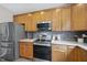 Close-up of the kitchen showcasing stainless steel appliances and wood cabinetry at 507 Littleport Dr, Rolesville, NC 27571