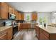 Spacious kitchen with an island, wooden cabinets, stainless steel appliances, and views to a deck at 507 Littleport Dr, Rolesville, NC 27571