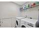 Functional laundry room with washer, dryer, and shelving for storage with white walls at 507 Littleport Dr, Rolesville, NC 27571