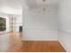 Open-concept dining room adjacent to living room features hardwood floors and modern light fixture at 5073 Tall Pines Ct, Raleigh, NC 27609