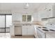 Bright kitchen with white cabinets, laminate counters, and stainless steel dishwasher at 5073 Tall Pines Ct, Raleigh, NC 27609