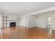 Open-concept living room with hardwood floors, fireplace, shelving and dining space at 5073 Tall Pines Ct, Raleigh, NC 27609
