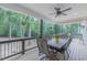 Relaxing covered patio with ceiling fan, outdoor furniture and views of the lush backyard at 5163 S River Rd, Lillington, NC 27546