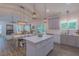 Open kitchen and dining area featuring a large island, pendant lighting, and sliding door to outdoor space at 5163 S River Rd, Lillington, NC 27546