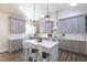 Bright, modern kitchen with gray cabinets, quartz countertops, island, and pendant lighting at 5163 S River Rd, Lillington, NC 27546